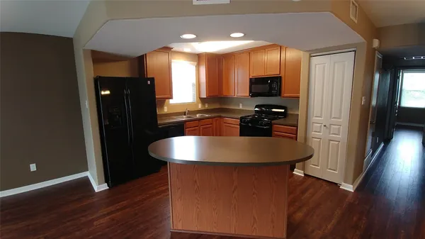 a kitchen with stainless steel appliances granite countertop a sink a stove and a refrigerator