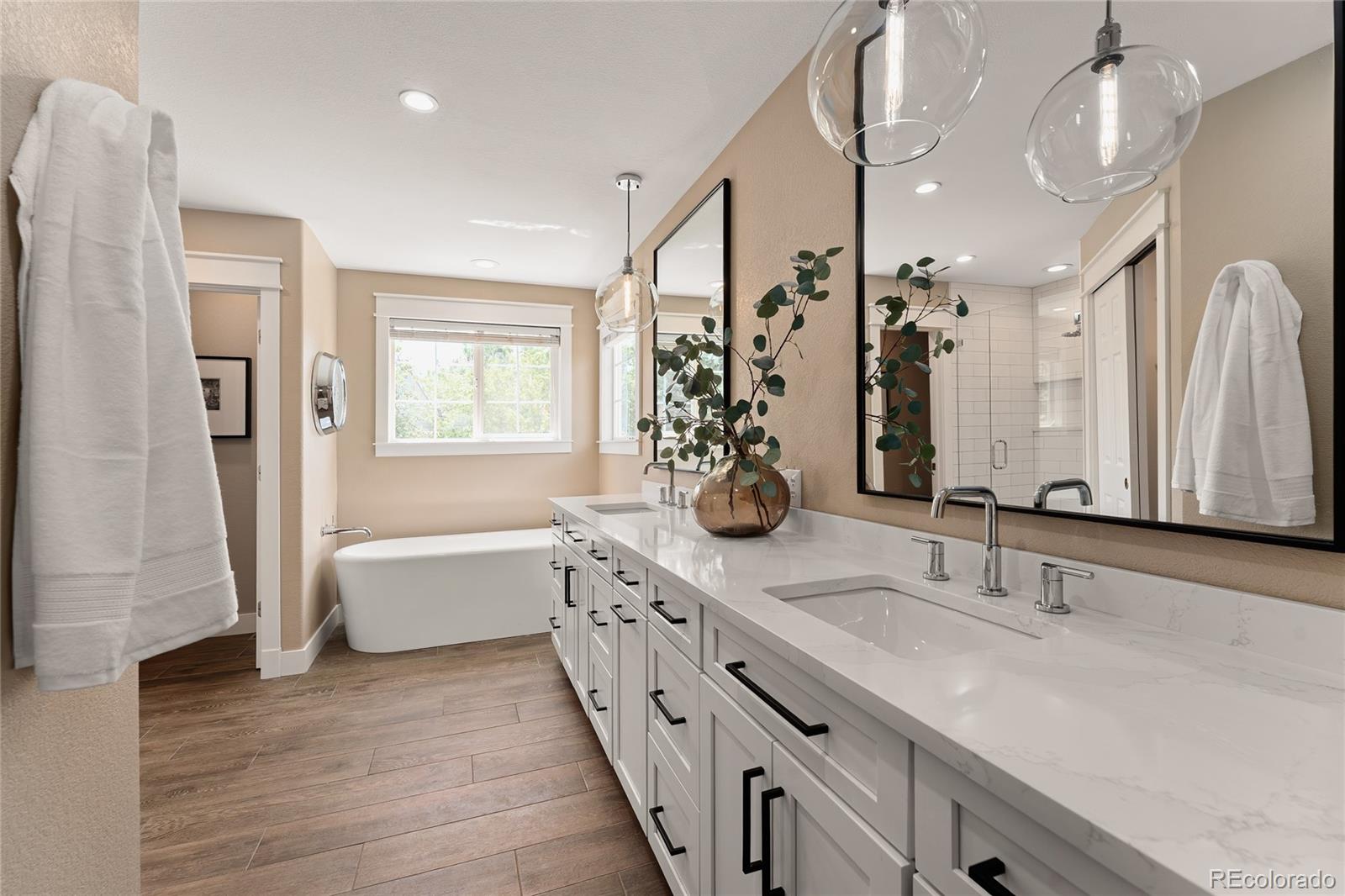 9441 South Hackberry Lane Highlands Ranch, CO 80129 - Photo 31 of 50 a bathroom with double vanity sinks a large mirror and a bathtub
