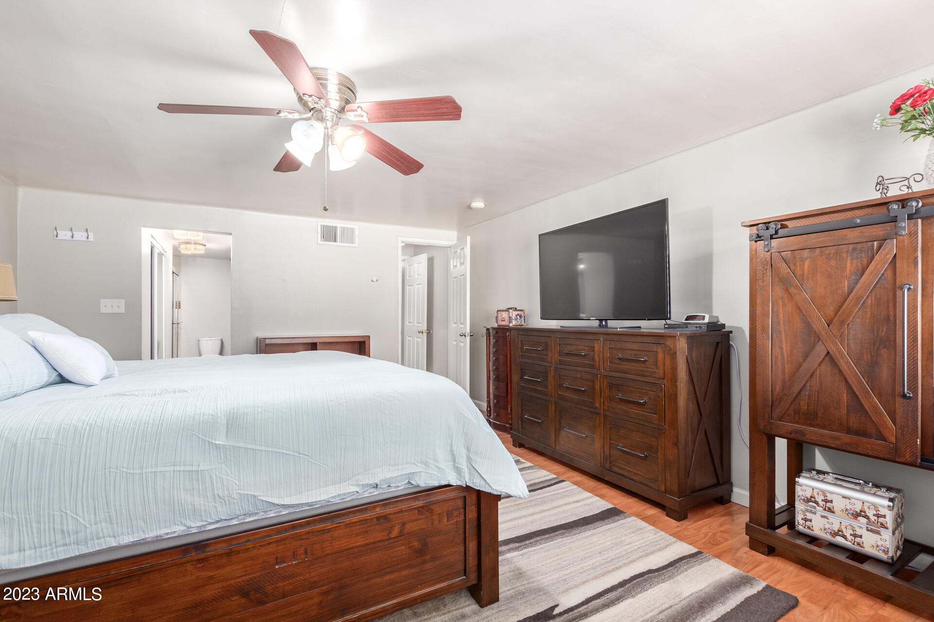 3834 North 34th Street Phoenix, AZ 85018 - Photo 16 of 29 a bedroom with a bed and a flat tv screen on dresser