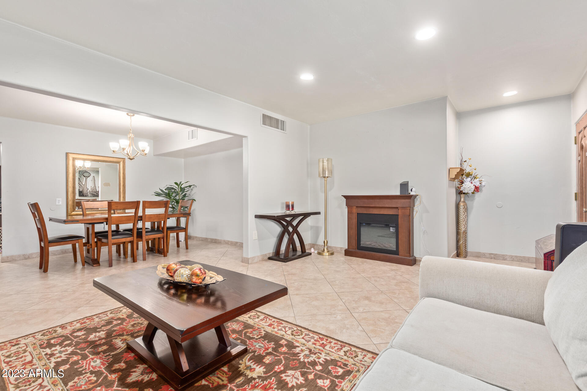 3834 North 34th Street Phoenix, AZ 85018 - Photo 6 of 29 a living room with furniture a dining table and a fireplace