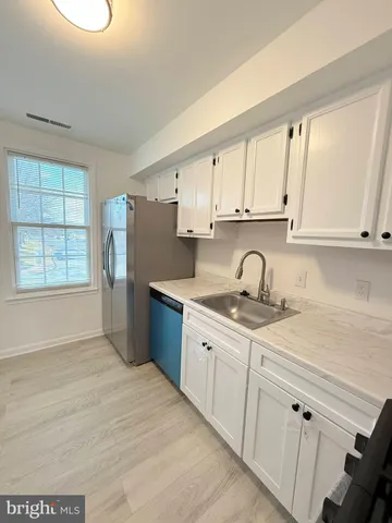 a kitchen with granite countertop a sink stainless steel appliances and cabinets