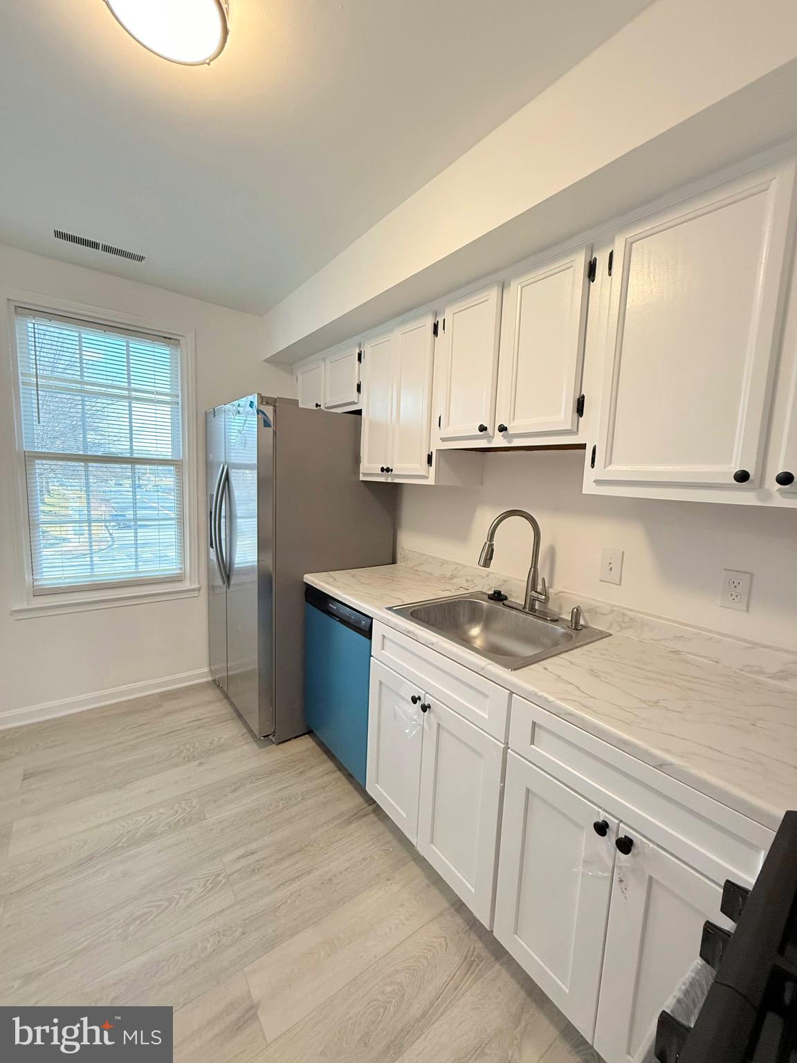 730 Quince Orchard Boulevard, Unit 730101 Gaithersburg, MD 20878 - Photo 14 of 47 a kitchen with granite countertop a sink stainless steel appliances and cabinets