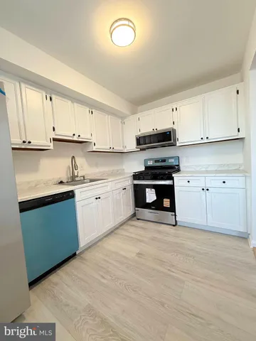 a kitchen with cabinets stainless steel appliances and a window