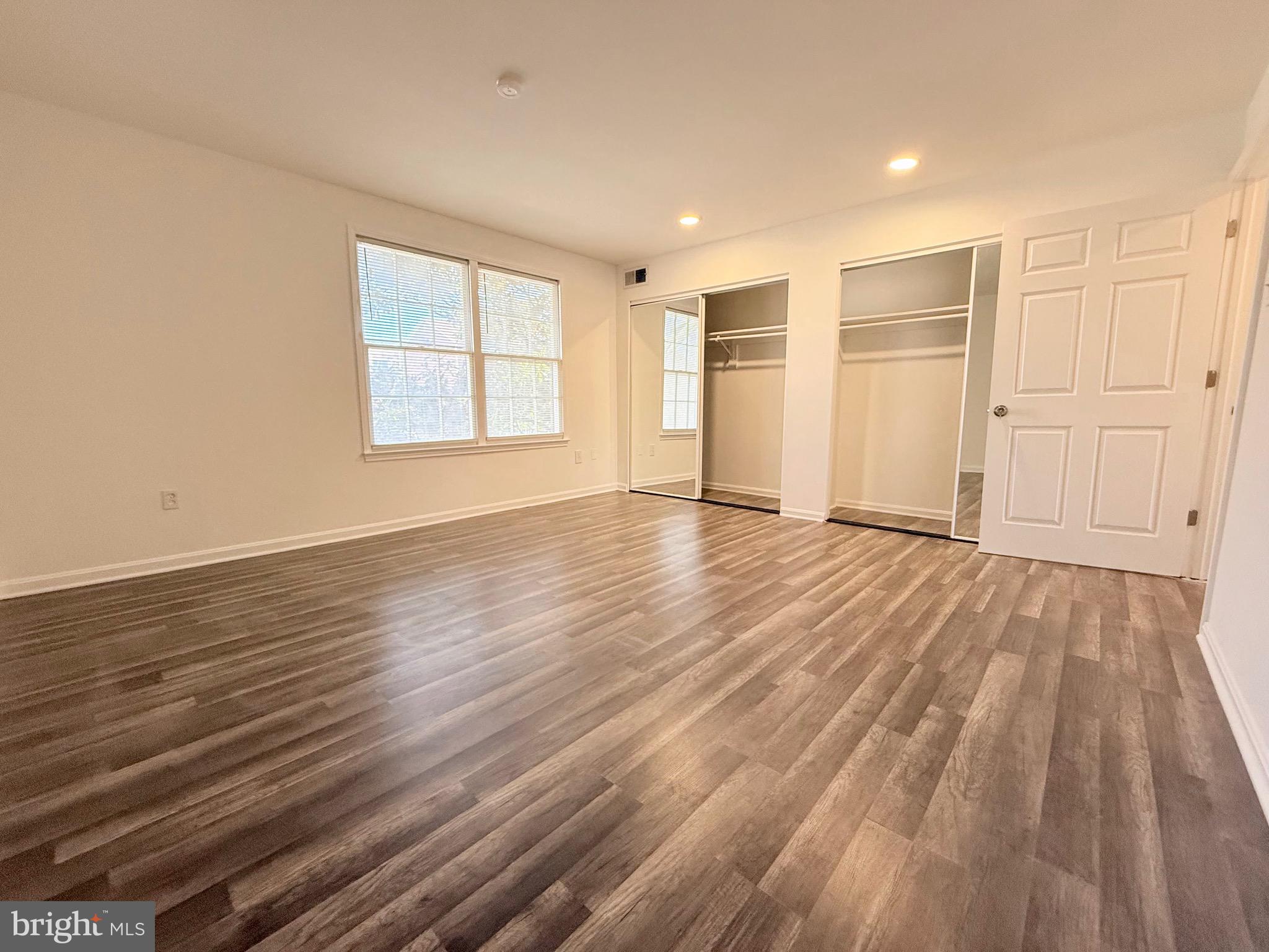 730 Quince Orchard Boulevard, Unit 730101 Gaithersburg, MD 20878 - Photo 22 of 47 a view of an empty room with wooden floor and a window