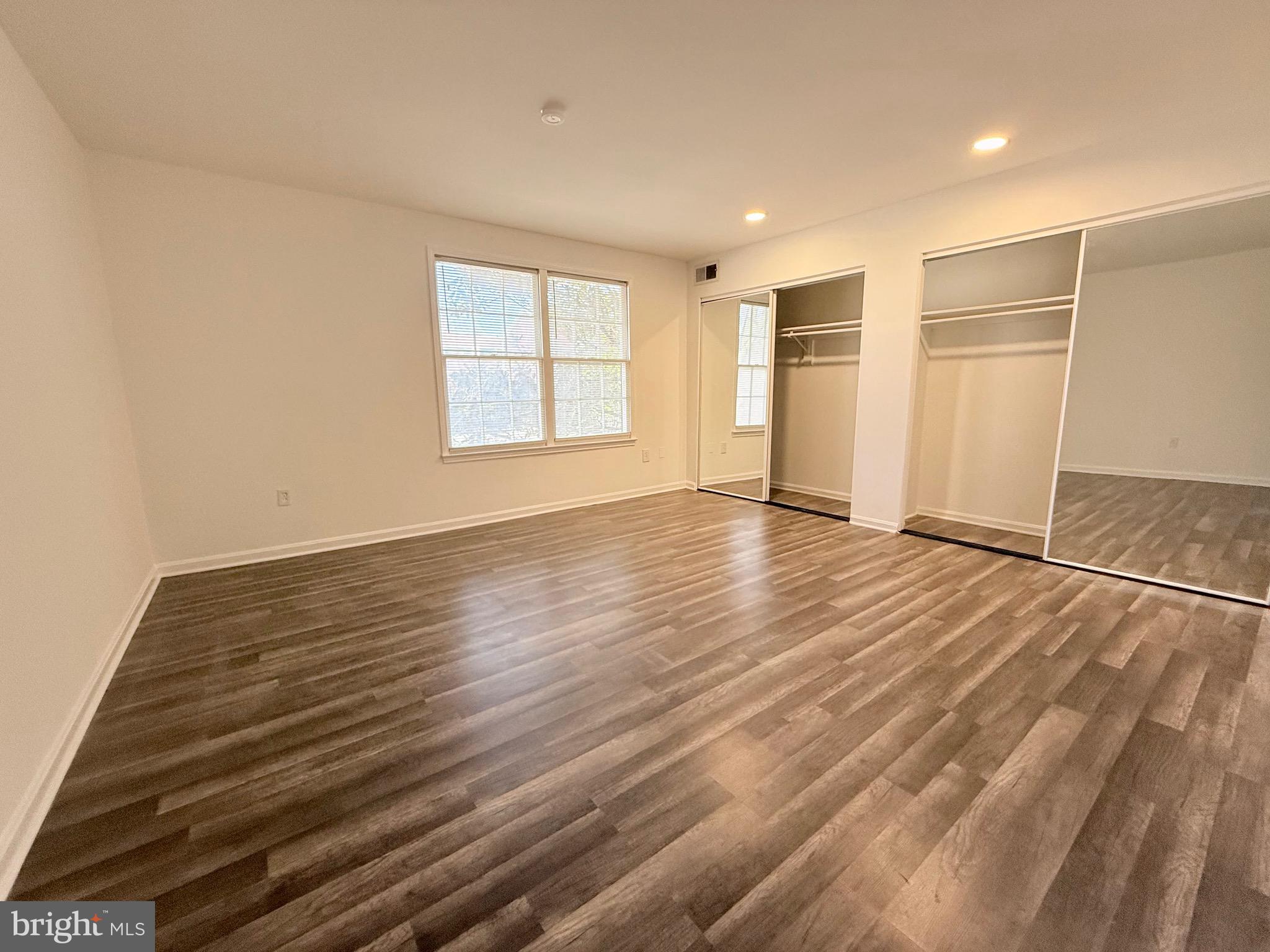 730 Quince Orchard Boulevard, Unit 730101 Gaithersburg, MD 20878 - Photo 23 of 47 an empty room with wooden floor and windows