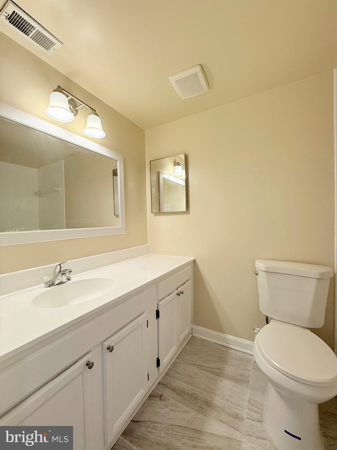 730 Quince Orchard Boulevard, Unit 730101 Gaithersburg, MD 20878 - Photo 25 of 47 a bathroom with a toilet a sink and mirror