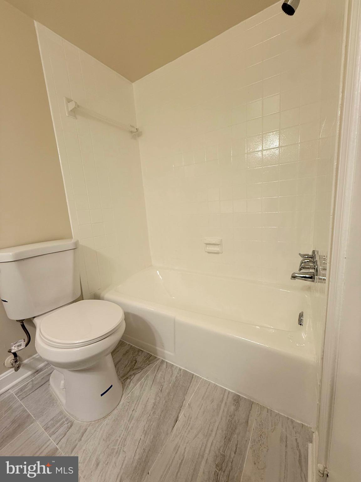 730 Quince Orchard Boulevard, Unit 730101 Gaithersburg, MD 20878 - Photo 28 of 47 a white toilet sitting next to a bath tub and a shower