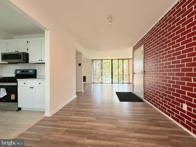 a view of empty room with wooden floor and windows