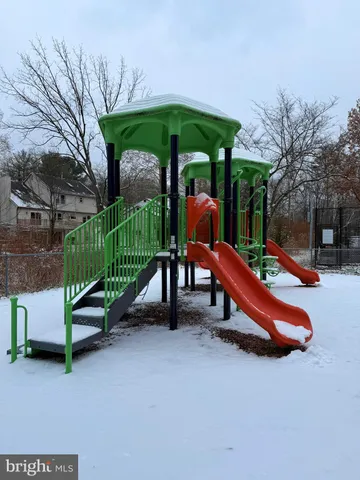 a garden with chairs and a table under an umbrella