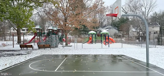 a view of a swimming pool with a bench and trees