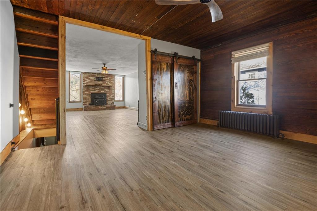 62 Allegheny Avenue Valencia, PA 16059 - Photo 6 of 30 an empty room with wooden floor windows and fireplace