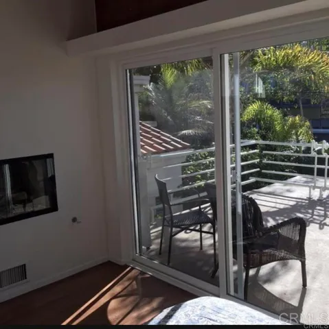 a living room with a fireplace furniture and a floor to ceiling window