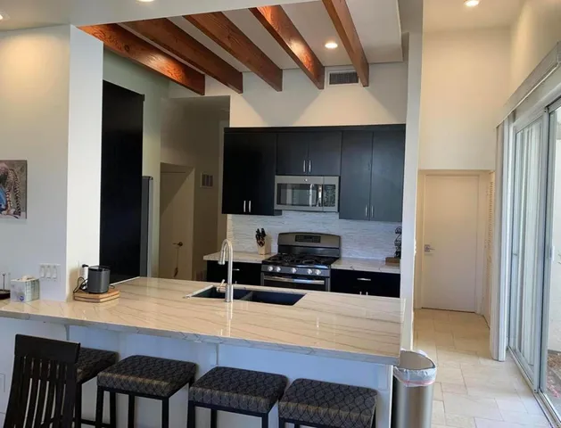 a kitchen with stainless steel appliances a stove a sink and a refrigerator