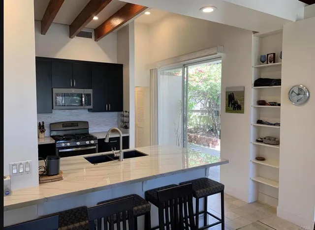 a kitchen with granite countertop a stove and a refrigerator
