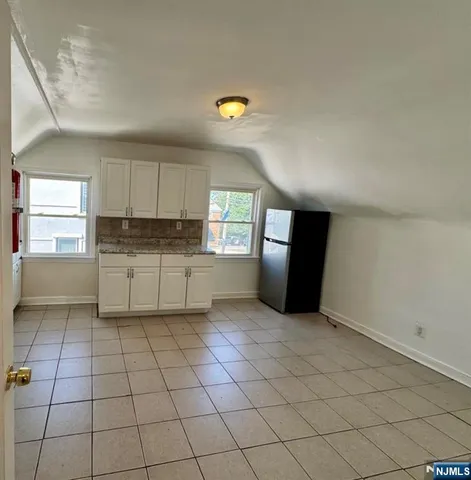 a kitchen with a cabinets a sink a window and stainless steel appliances
