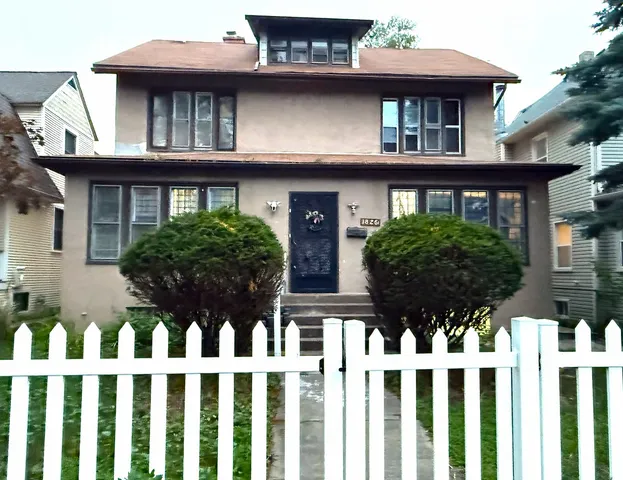 a view of a white house with large windows and a small yard