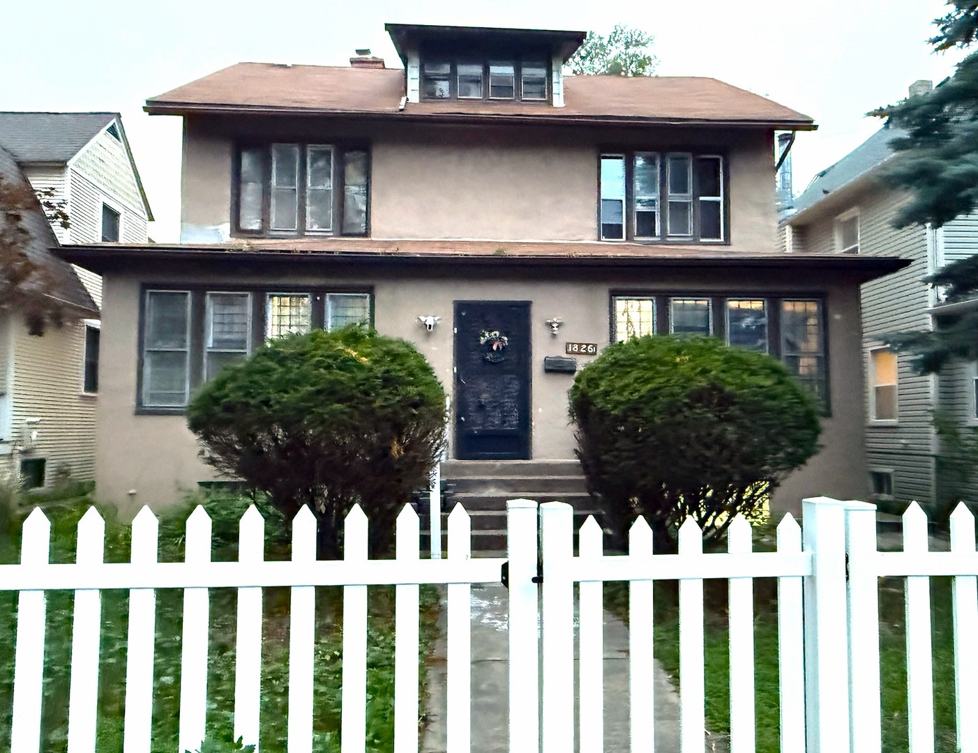 a view of a white house with large windows and a small yard