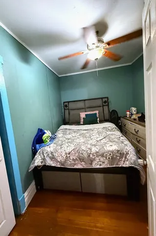 a bedroom with a bed and a fan