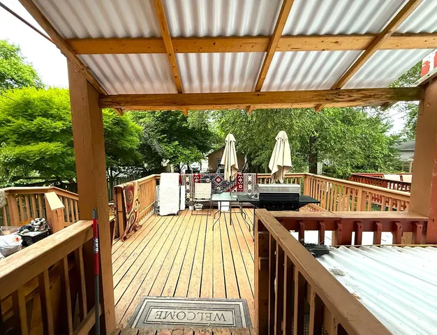 a view of a balcony with chairs and wooden floor