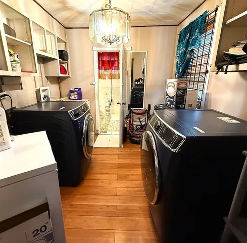 a kitchen with stainless steel appliances granite countertop a sink dishwasher and a refrigerator with wooden floor