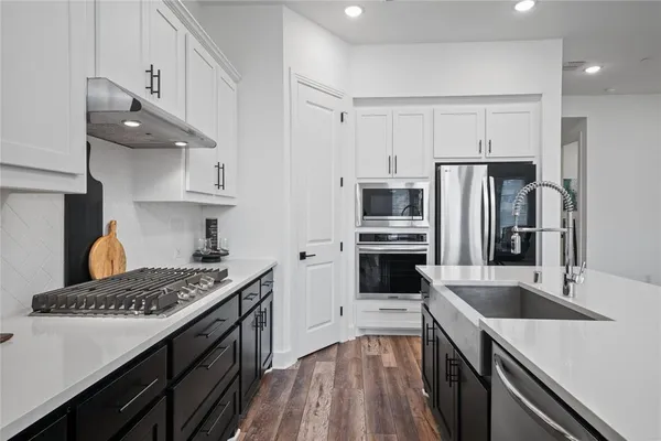 a kitchen with stainless steel appliances a sink stove and refrigerator