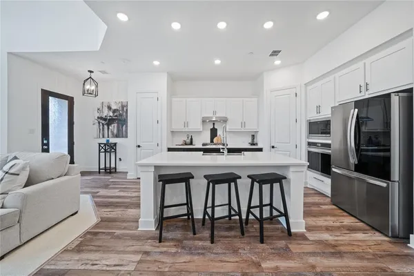 a kitchen with stainless steel appliances granite countertop a table and chairs