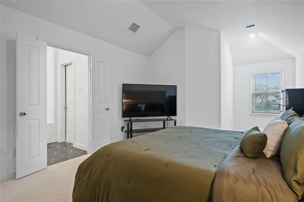 a bedroom with a bed and a flat screen tv