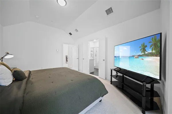 a bedroom with a bed and a flat screen tv