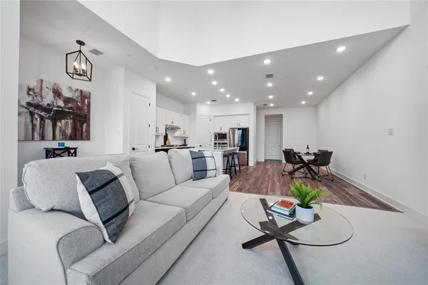 a living room with furniture kitchen view and a table