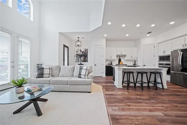 a living room with furniture and a dining table with kitchen view