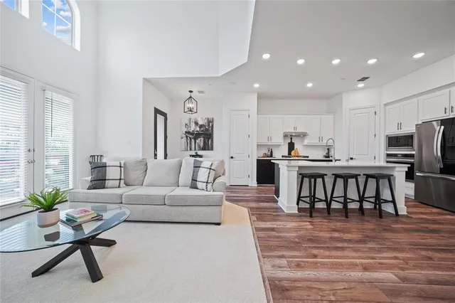 a living room with furniture and a dining table with kitchen view