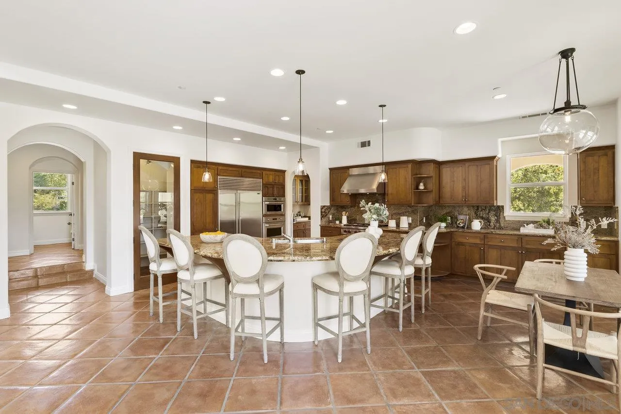 20919 Questhaven Road San Marcos, CA 92078 - Photo 17 of 54 a dining room with stainless steel appliances kitchen island granite countertop a dining table chairs and view living room