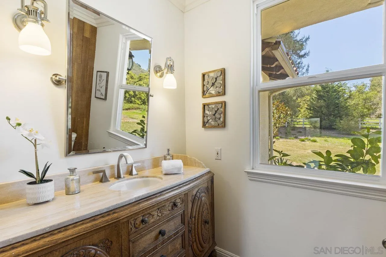 20919 Questhaven Road San Marcos, CA 92078 - Photo 21 of 54 a bathroom with a granite countertop sink mirror and window
