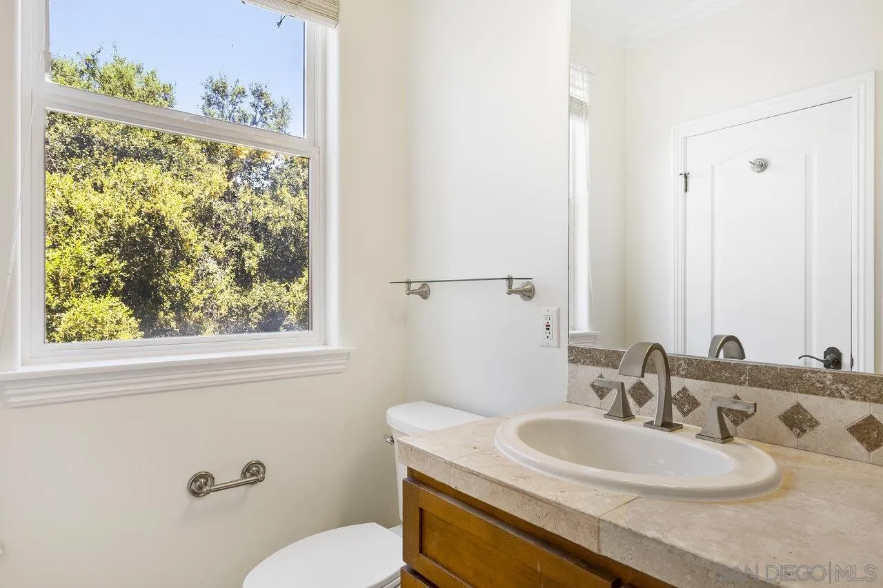 20919 Questhaven Road San Marcos, CA 92078 - Photo 23 of 54 a bathroom with a granite countertop sink vanity mirror and toilet