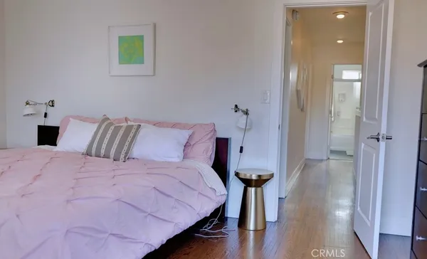 a bedroom with a bed and painting on the wall