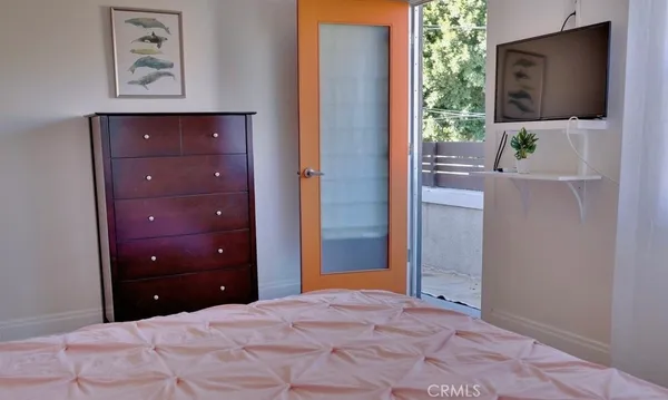 a bedroom with a bed and a flat screen tv