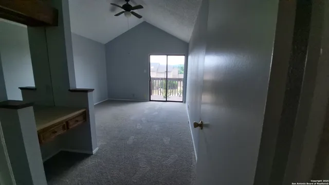 an empty room with a window and a fan