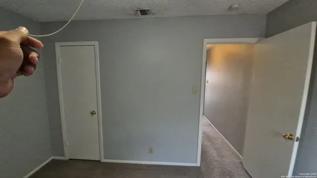 a view of a backyard with large trees and wooden fence