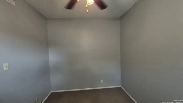 a view of a livingroom with a chandelier fan and a window