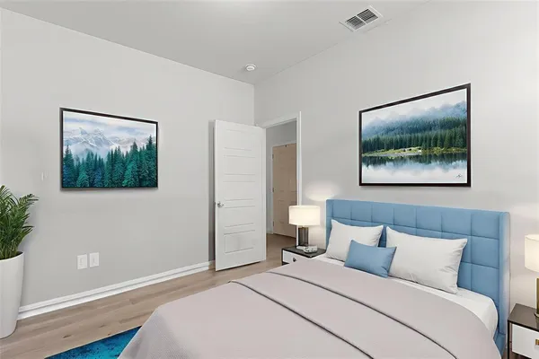 a bedroom with a bed and a painting on the wall