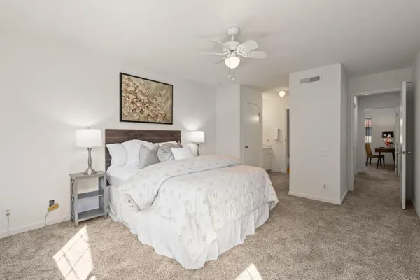 a spacious bedroom with a bed and a chandelier