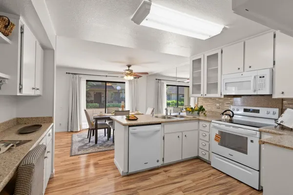 a kitchen with a stove sink and cabinets