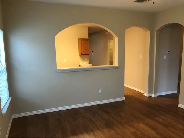 an empty room with wooden floor and a window