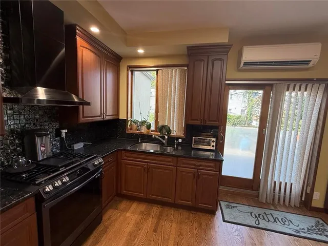 a kitchen with granite countertop a sink stove and cabinets