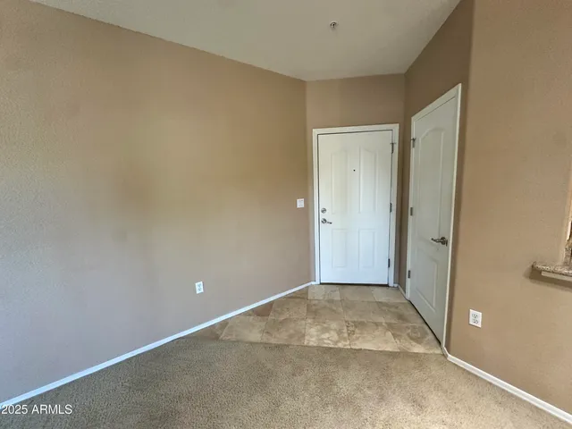 a view of a livingroom with a chandelier fan and wooden floor