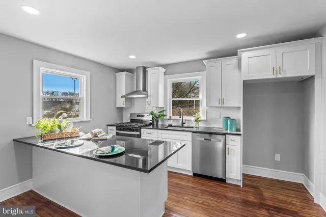 a kitchen with a sink and wooden floor