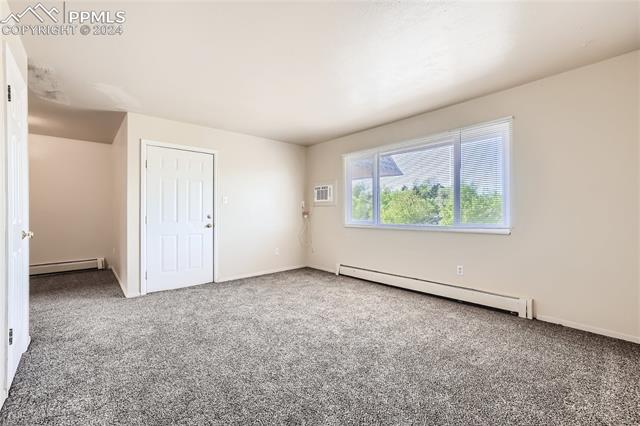 6450 Chippewa Road Colorado Springs, CO 80915 - Photo 2 of 10 Livingroom with an AC wall unit, a baseboard radiator, and carpet flooring