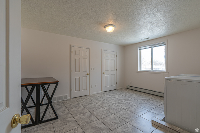 1045 Fox Farm Road Logan, UT 84321 - Photo 44 of 65 Laundry area with washer / clothes dryer, a textured ceiling, and a baseboard heating unit