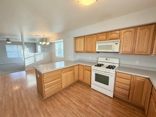 a kitchen with stainless steel appliances granite countertop a stove a sink and a microwave