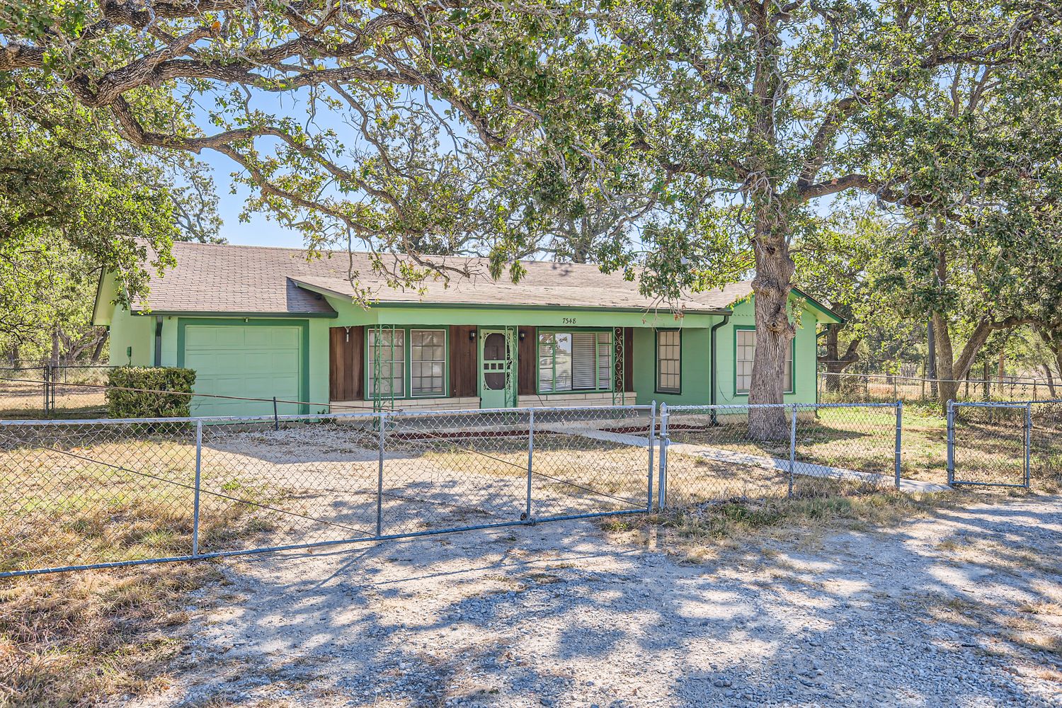 7348 Highway 183 Lockhart, TX 78644 - Photo 12 of 13 Single story home with an attached garage, covered porch, driveway, and a fenced front yard